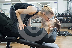 Sporty couple kissing in gym.