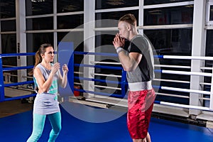 Sporty couple practicing boxing in a boxing ring