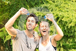 Sporty couple refreshing with cold water after run training