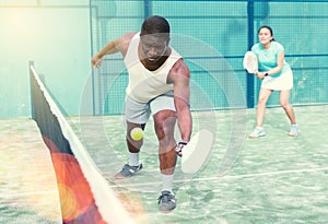 Sporty emotional man playing doubles paddle tennis