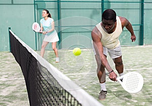 Sporty emotional man playing doubles paddle tennis
