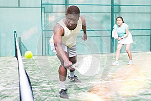 Sporty emotional man playing doubles paddle tennis