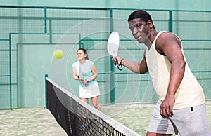 Sporty emotional man playing doubles paddle tennis