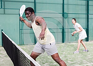 Sporty emotional man playing doubles padel game