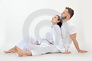 Sporty family wearing white clothes sitting on floor after training, relaxing, looking up on white background. Love.