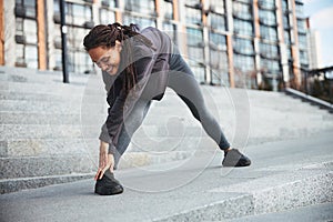 Sporty female with cornrows doing a stretching exercise