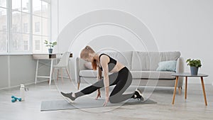 Sporty Female Doing Legs Stretches Exercising On Mat At Home