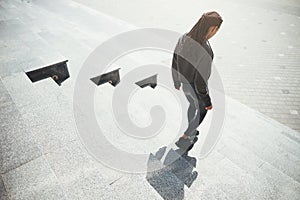 Sporty female with stylish Afro bunches going down the stairs