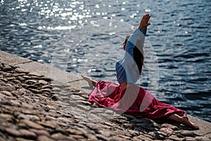 Sporty fit caucasian woman doing asana Virabhadrasana 2 Warrior pose posture in nature. photo