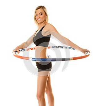 Sporty fit girl doing exercise with hula hoop.