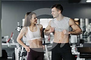 Sporty fitness couple showing in gym. Beautiful athletic man and woman, muscular torso abs