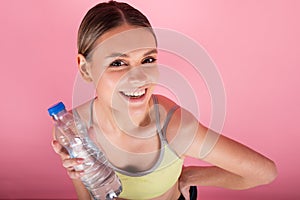 SPORTY FITNESS GIRL HOLDING BOTTLE OF WATER