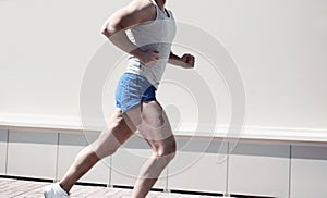 Sporty fitness man running in city - sport, workout and healthy lifestyle concept