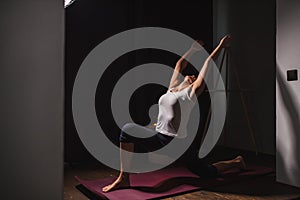 Sporty fitness woman doing exercises, stretching at home