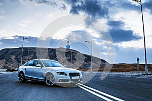 Sporty German Audi sedan on a winding mountain road. At evening