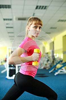 Sporty girl doing exercise with dumbbells