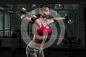 Sporty girl doing exercise with dumbbells