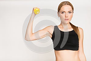 Sporty girl doing exercise with dumbbells and looking at camera