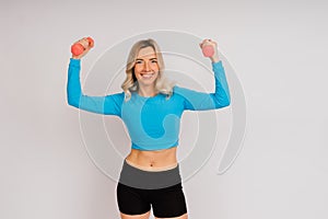 Sporty girl doing exercise with dumbbells, silhouette studio shot over dark and whitebackground