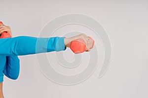 Sporty girl doing exercise with dumbbells, silhouette studio shot over dark and whitebackground