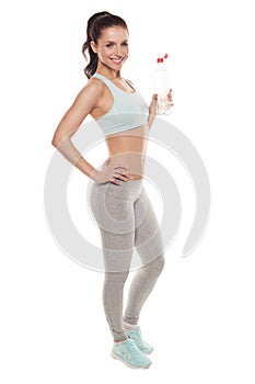Sporty girl drinking water from a bottle after a workout, fitness training, isolated on white background