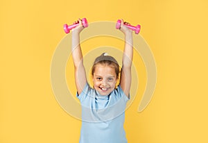 Sporty girl with dumbbells. Fitness kids, health and energy. Healthy kids lifestyle. Kid exercising with dumbbell. Sport