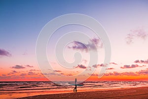 Sporty girl go to surfing. Woman in wetsuit and sunset or sunrise on ocean