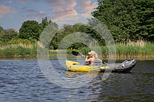 A sporty girl goes kayaking on the Pirita river on a summer day