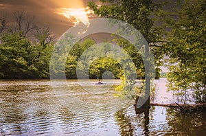 Sporty girl kayaking on The RiviÃ¨re-des-Mille-ÃŽles Park in Laval at sunset