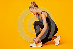 Sporty Girl Lacing Shoes Before Workout, Studio Shot