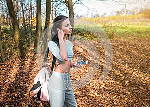 Girl listening to music on headphones in the park