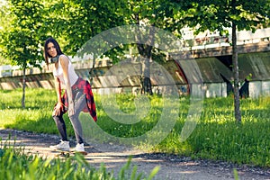 Sporty girl riding skateboards on street
