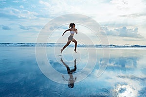 Sporty girl running by beach along sea surf