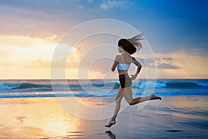 Sporty girl running by beach along sea surf