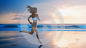 Sporty girl running by beach along sea surf