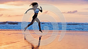 Sporty girl running by beach along sea surf