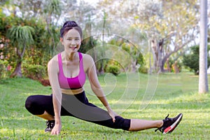 Sporty girl`s warm up exercise outdoor in the park