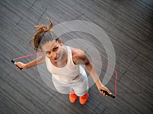 Sporty girl with skipping rope in motion. Top view