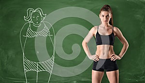 Sporty girl with slim body and picture of fat woman drawn at green chalkboard background