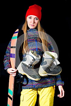 Sporty girl with snowboard equipment on black background in stud
