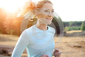 Sporty girl in sportswear jogging, running and training outdoors on a sunny day in summer