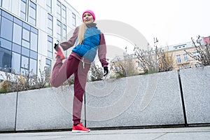 Sporty girl stretching outdoor on city street.