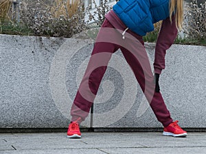 Sporty girl stretching outdoor on city street.