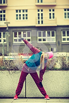 Sporty girl stretching outdoor on city street.