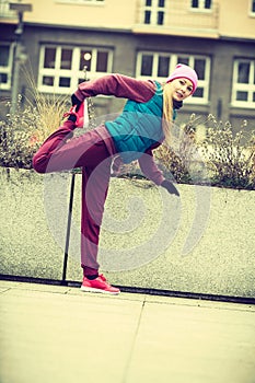 Sporty girl stretching outdoor on city street.