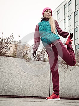 Sporty girl stretching outdoor on city street.