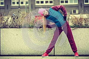 Sporty girl stretching outdoor on city street.