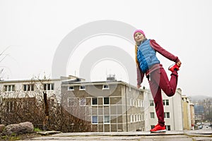 Sporty girl stretching outdoor on city street.