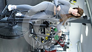 Sporty girl trains on an aerobike in the gym. Fitness girl doing cardio on exercise bike.