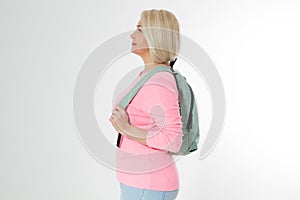 Sporty happy middle age beautiful woman with backpack isolated on white background. Copy space. Mid aged women healthy lifestyle.